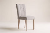 Adelina upholstered dining chair in light grey woven fabric with square pale oak legs on a studio backdrop