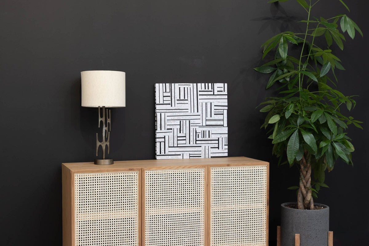 Adeline table lamp on a cane-front sideboard against a charcoal wall