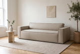 Agerola sofa in Sand in a bright Outremont, Montreal living room with herringbone oak floors and a travertine side table