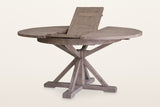 Aggius table in Rustic Sundried with its butterfly leaf half raised from inside the top, on a warm white studio backdrop