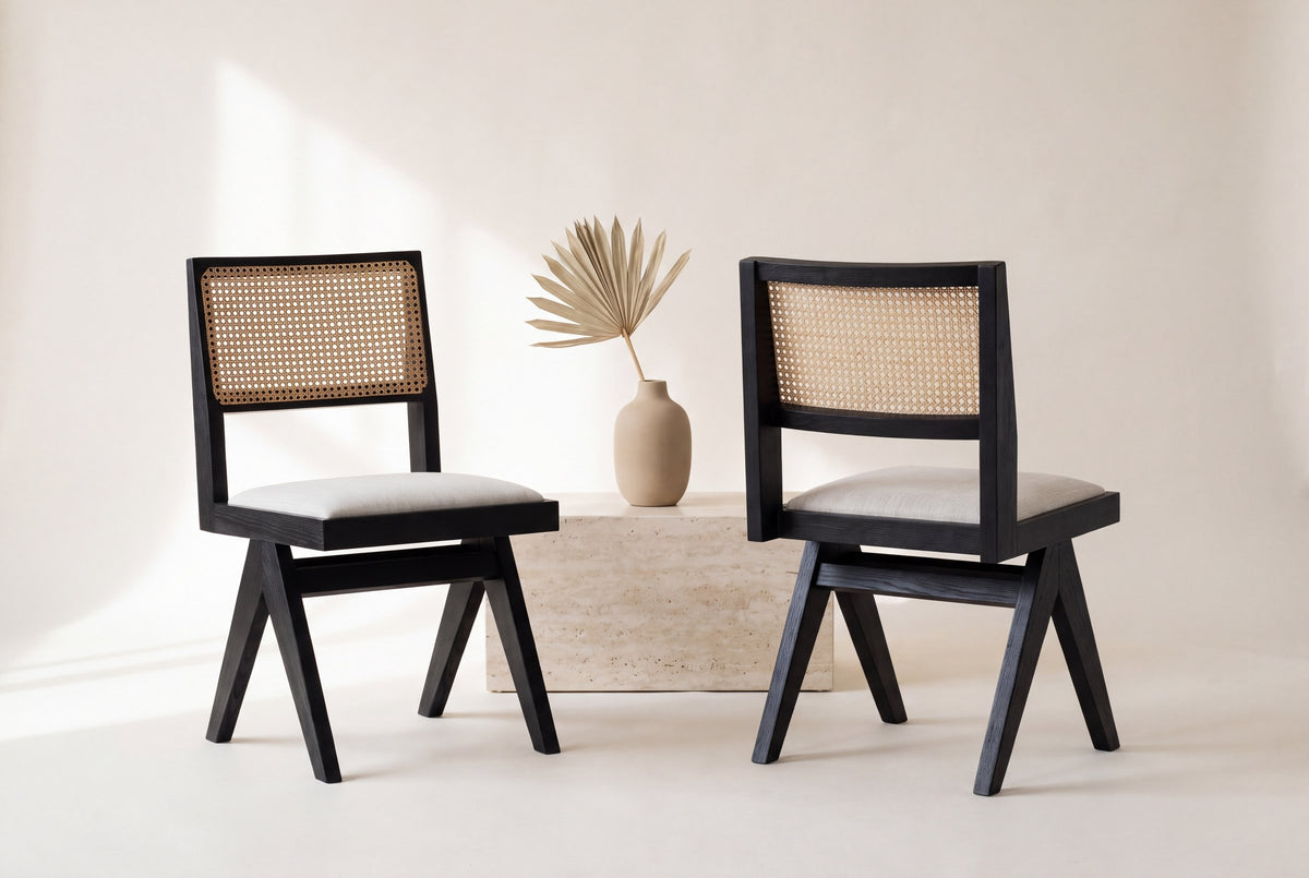 Two Alaya dining chairs, front and back views, beside a travertine block