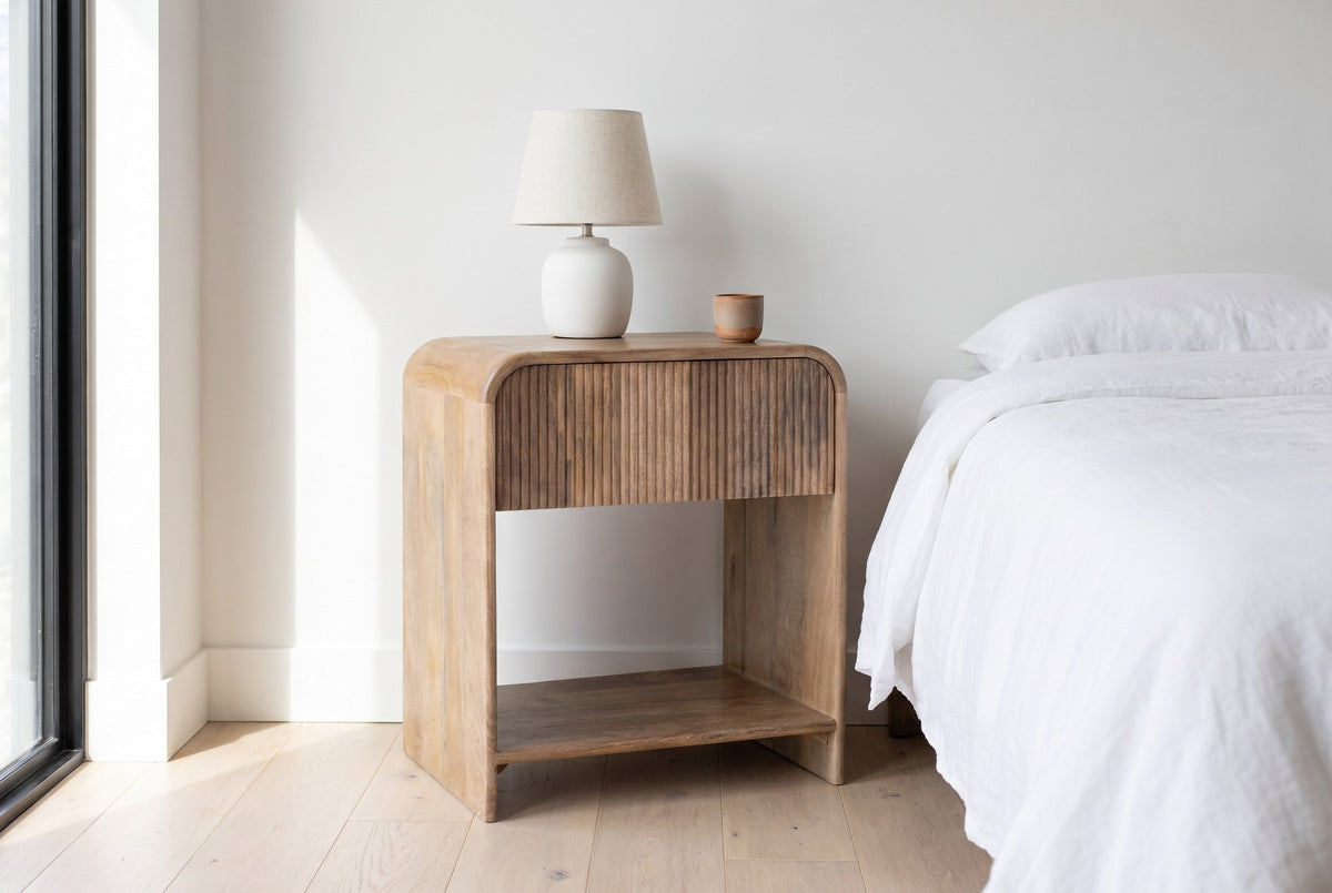 Alberona nightstand in the Natural finish beside a bed with white linen in a bright Kelowna lake house bedroom