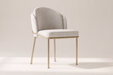 Alexander ivory fabric dining chair with brass legs on an off-white studio backdrop