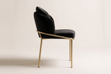 Alexander black velvet dining chair with brass legs in side view on an off-white studio backdrop