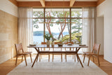 Amandola dining table in Light Walnut in a Salt Spring Island dining room with a sandstone wall