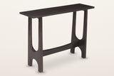 Amelia sculpted mango wood console table in mocha, three-quarter view on a warm white studio backdrop