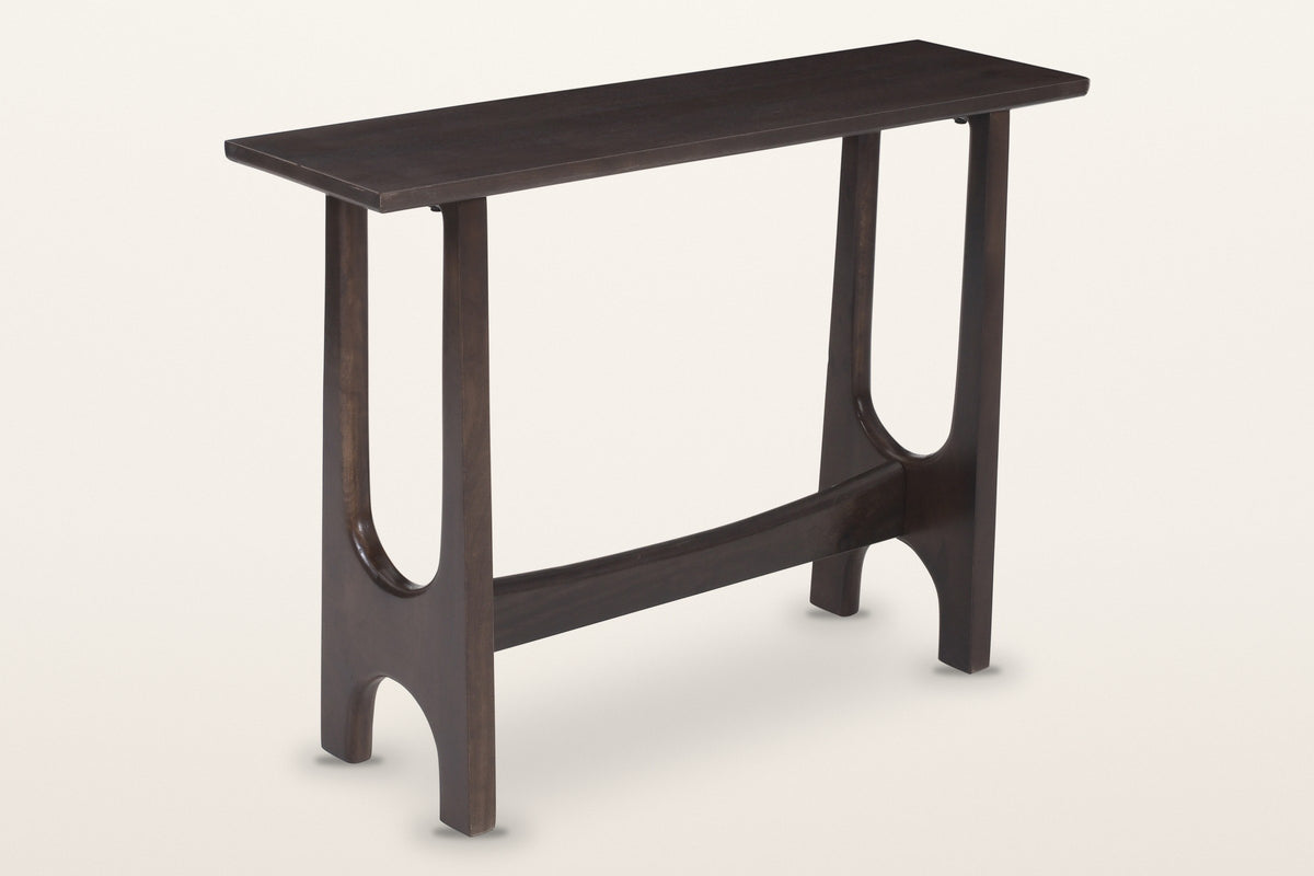 Amelia sculpted mango wood console table in mocha, three-quarter view on a warm white studio backdrop