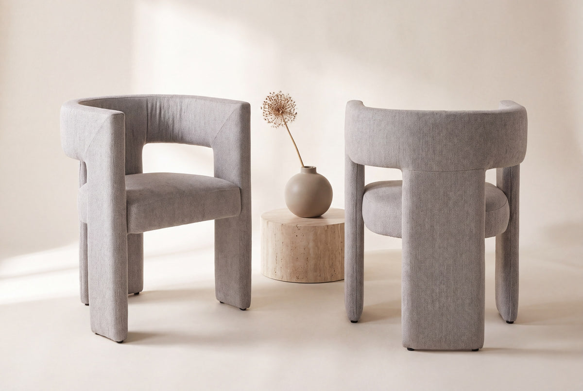 Two Andrea dining chairs, front and back views, beside a travertine side table