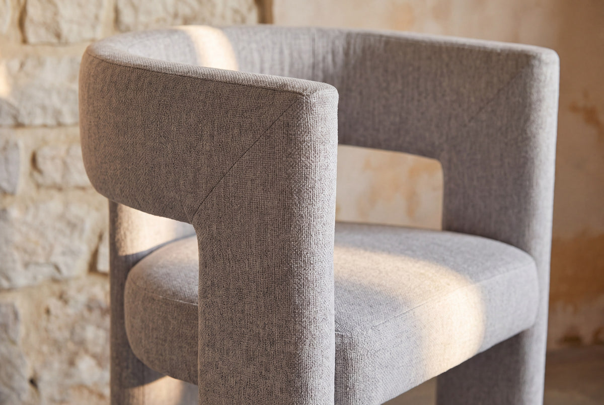 Close-up of the light grey woven fabric on the back and seat of the Andrea chair