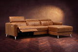 The Andria power reclining sectional on a walnut herringbone floor with the arm-end power recliner open: its two-tier footrest out and its headrest raised. Shown in Antiqued Caramel, Right chaise.