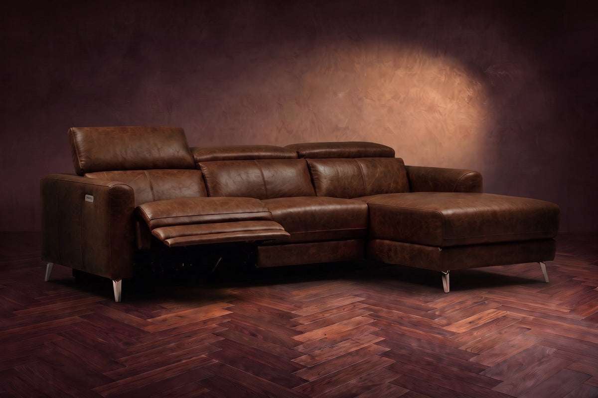The Andria power reclining sectional on a walnut herringbone floor with the arm-end power recliner open: its two-tier footrest out and its headrest raised. Shown in Burnished Chestnut, Right chaise.