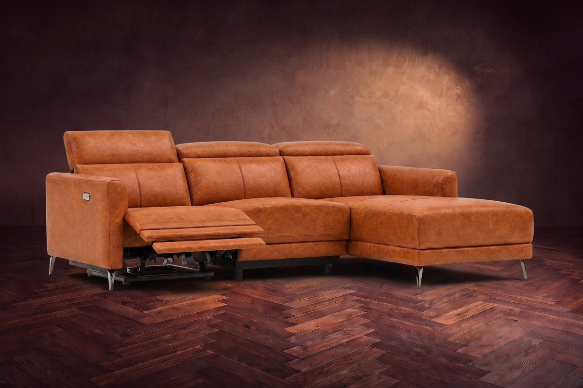 The Andria power reclining sectional on a walnut herringbone floor with the arm-end power recliner open: its two-tier footrest out and its headrest raised. Shown in Tuscan Cognac, Right chaise.