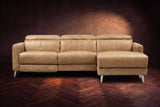 The Andria distressed leather reclining sectional seen from the front on a walnut herringbone floor, headrests down and the footrest closed. Shown in Washed Sand, Right chaise.