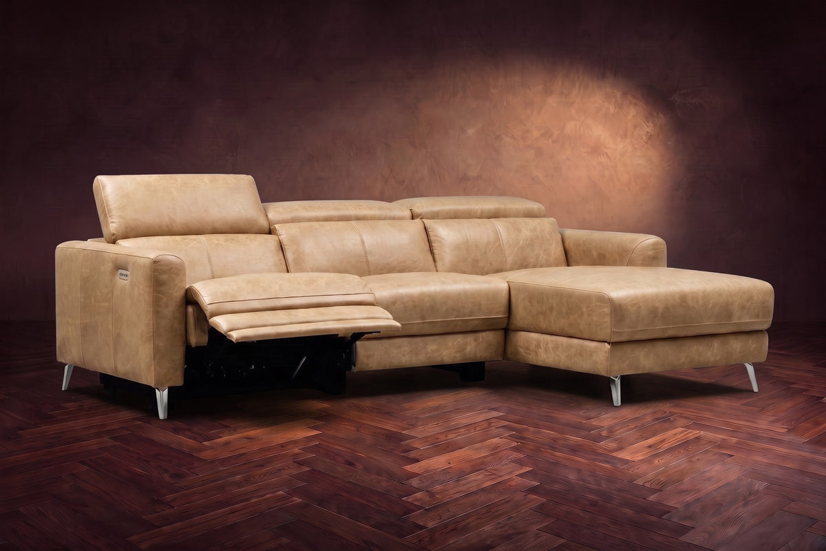 The Andria power reclining sectional on a walnut herringbone floor with the arm-end power recliner open: its two-tier footrest out and its headrest raised. Shown in Washed Sand, Right chaise.