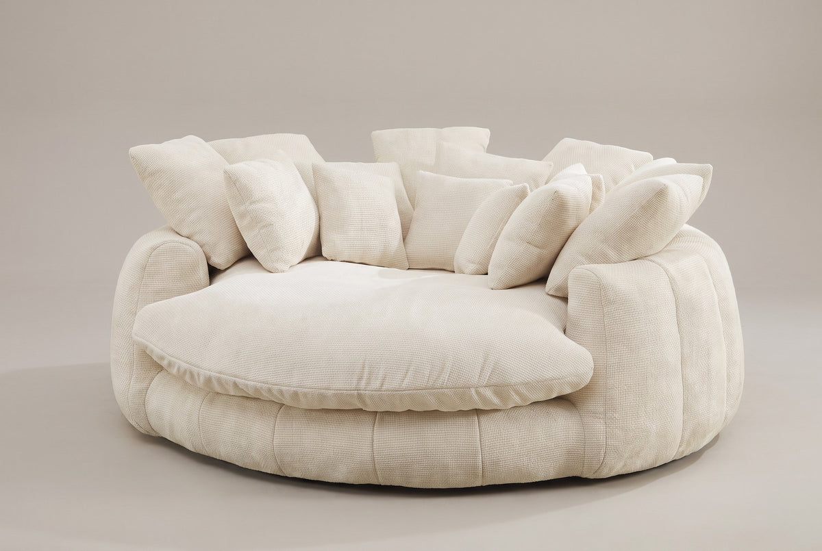 Aosta oversized round lounge chair in beige chenille, three-quarter view on a warm grey studio backdrop