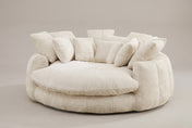 Aosta oversized round lounge chair in beige chenille, three-quarter view on a warm grey studio backdrop