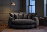 Aosta lounge chair in a Toronto reading corner at dusk under a glowing brass arc floor lamp (Black)