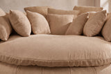 Close-up of the thick round seat cushion in coffee basket-weave chenille, square pillows behind