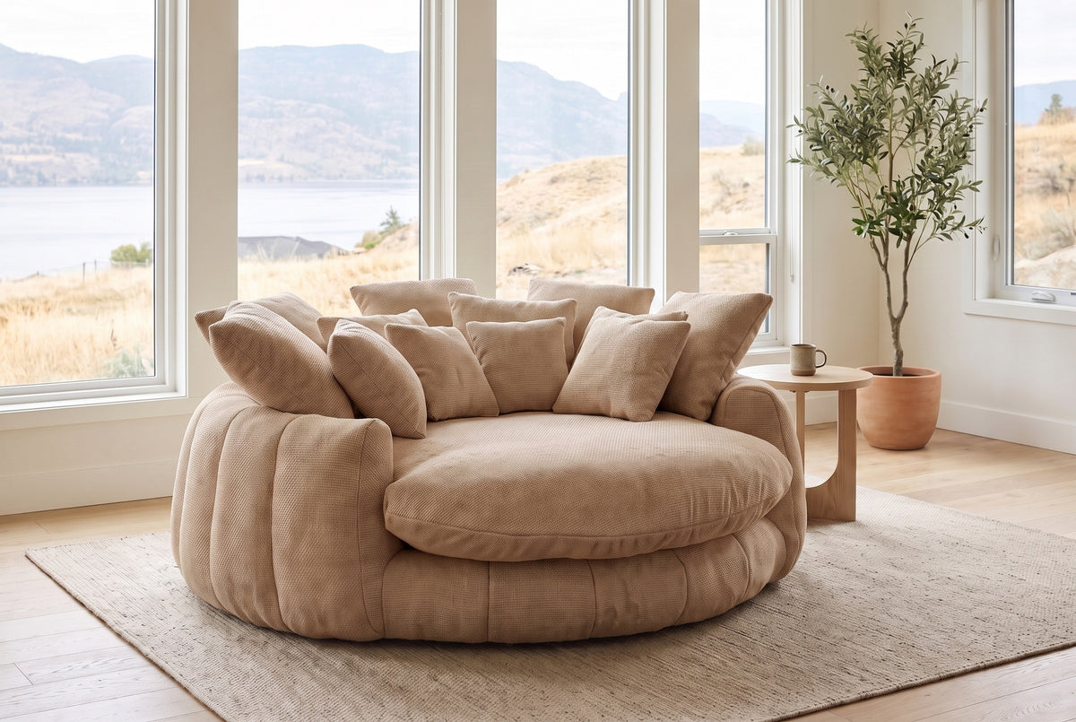 Aosta lounge chair in a Kelowna lake-house living room in the morning, the lake and dry hills beyond the windows (Coffee)