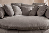 Close-up of the thick round seat cushion in grey basket-weave chenille, square pillows behind