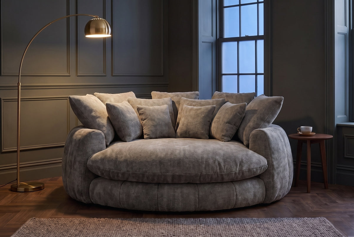 Aosta lounge chair in a Toronto reading corner at dusk under a glowing brass arc floor lamp (Grey)