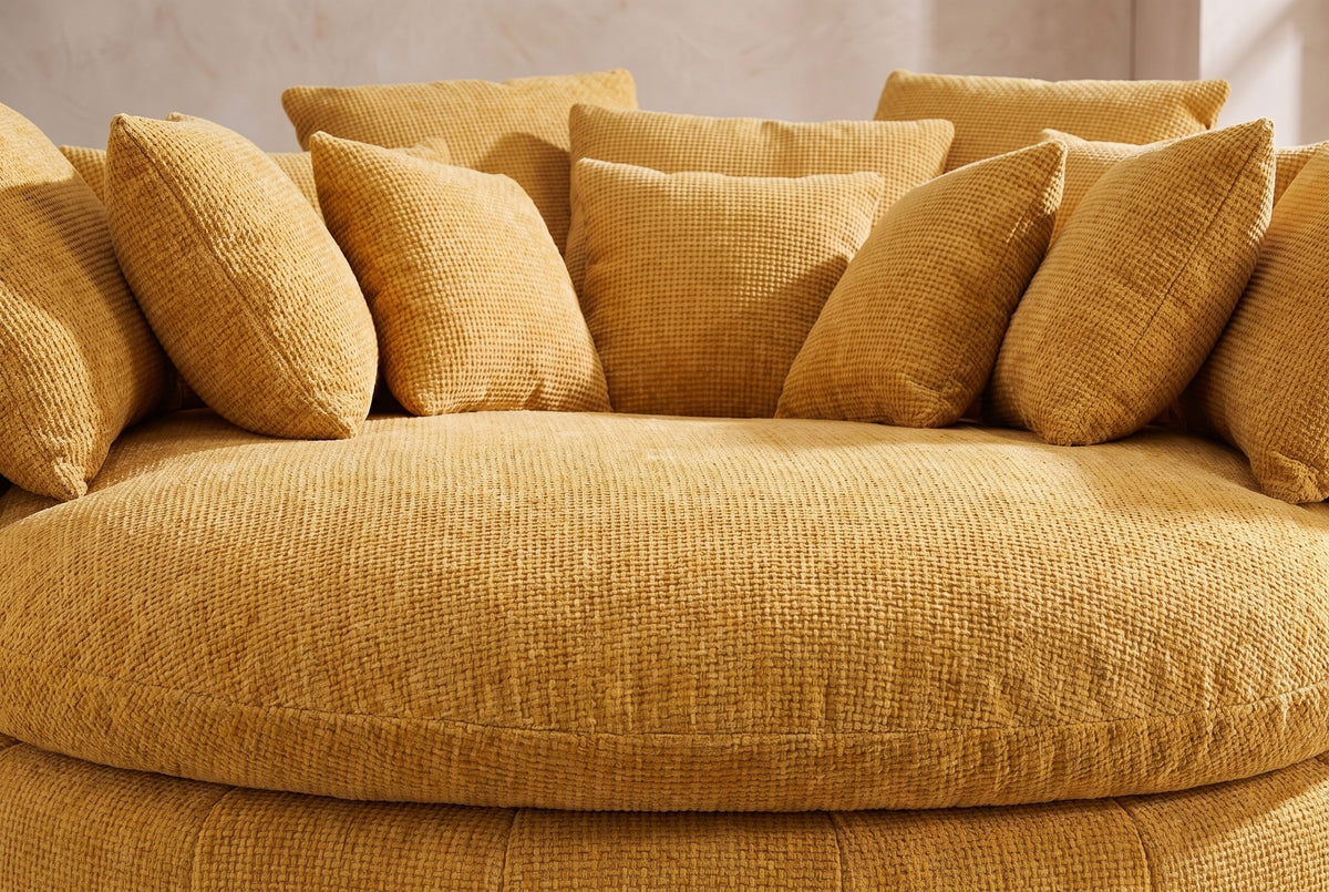 Close-up of the thick round seat cushion in yellow basket-weave chenille, square pillows behind