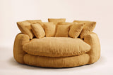 Aosta lounge chair in yellow, straight front view: one thick round seat cushion inside a low channelled ring, square pillows along the back