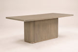 Aquileia 84-inch fluted pedestal dining table in Natural, three-quarter view on a warm off-white backdrop
