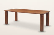 Arcevia solid mango dining table in Brown, three-quarter view on a warm white studio backdrop