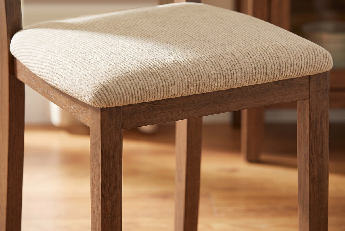 Close-up of the Arden padded seat in beige ribbed fabric on its walnut-finish wooden frame
