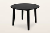 Arden round drop-leaf dining table in Black, both leaves up, three-quarter view on a warm white studio backdrop