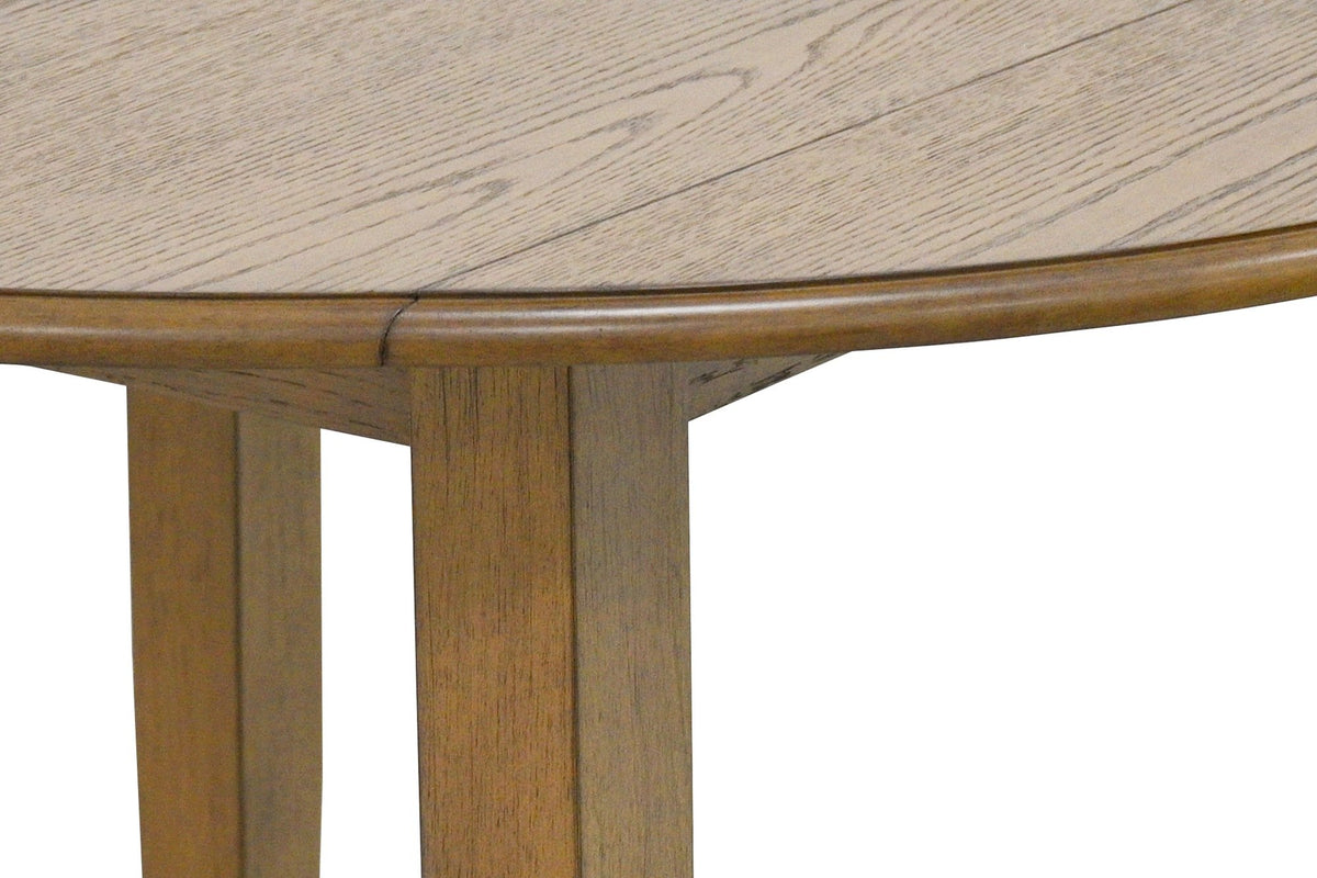 Close-up of the Arden table in Walnut: the oak grain, a leaf seam meeting the rounded moulded edge, and the square legs below