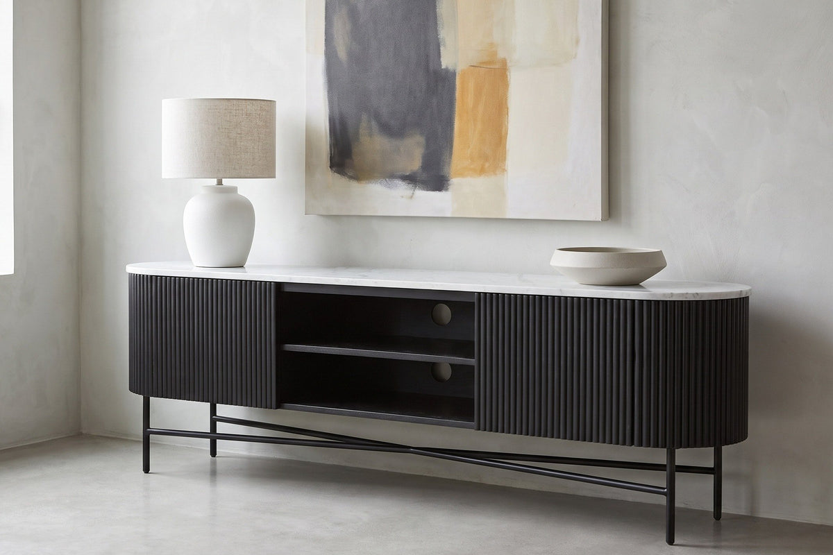 Arpino media console in black with a white marble top in a pale Montreal loft, a white lamp and a stoneware bowl on top