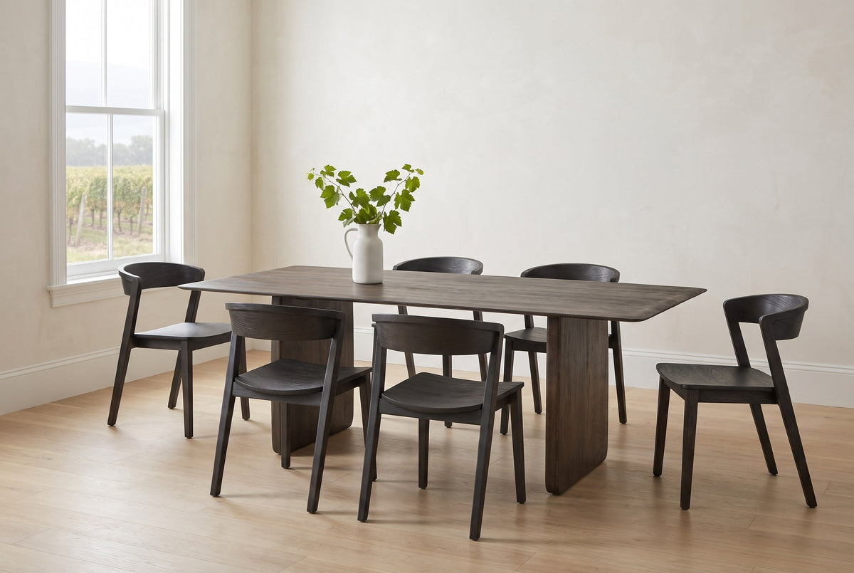 Arquata 7-piece dining set in mocha in a heritage dining room in Niagara-on-the-Lake: the slab-leg mango wood table with six curved-back chairs, vineyard rows through the window