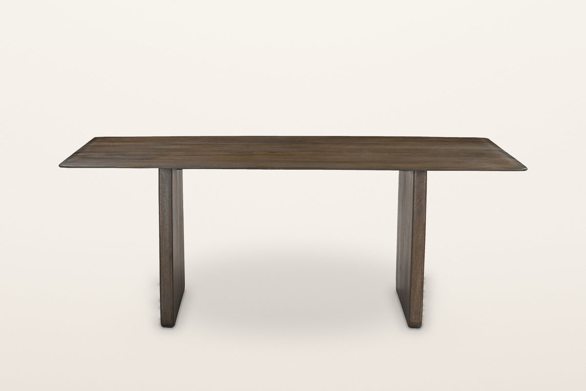Arquata dining table in mocha seen along its long side: a thin top on two slab legs set in from the ends