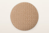 The Arvier pouf's padded round lid seen from above: camel jute with cream cotton dashes