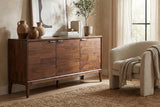 Ashby Natural Brown acacia sideboard styled with vases and art beside a cream armchair