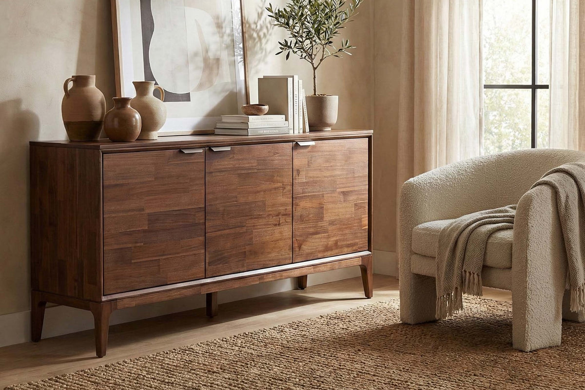 Ashby Natural Brown acacia sideboard styled with vases and art beside a cream armchair
