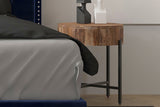 Ashford mango wood side table used as a nightstand beside a navy upholstered bed