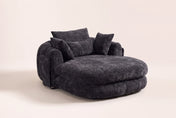 Asolo chenille chaise lounge chair in Black, three-quarter view on a warm cream studio backdrop