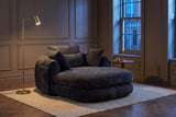 Asolo chaise lounge in a panelled Toronto living room at dusk beside a brass floor lamp