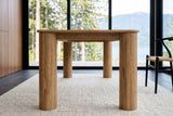 Close-up of the Atzara base from one end at seat height: two column legs and the slim apron between them, Howe Sound behind