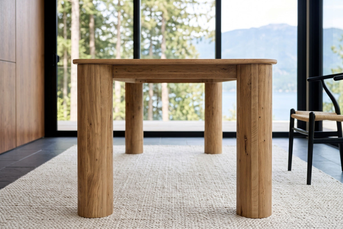 Close-up of the Atzara base from one end at seat height: two column legs and the slim apron between them, Howe Sound behind