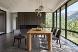 Atzara dining table seen from one end in a Fernie house in the BC Rockies, with a dark cedar fireplace wall