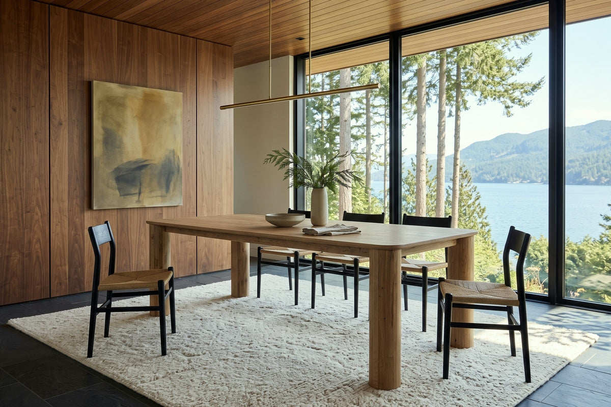 Atzara dining table in a Gibsons house above Howe Sound, with walnut panelling, a glass wall to cedars, firs and the water