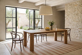 Atzara dining table in a stone villa in Gordes, Provence, with glass doors open to an olive and lavender courtyard