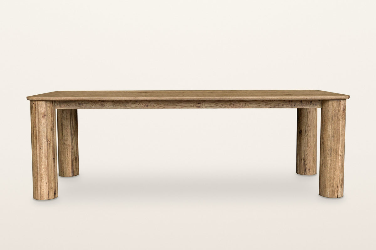 Atzara dining table in Natural, straight front view on a warm white studio backdrop: four column legs