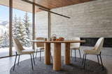 Atzara round dining table in a Silver Star mountain house near Vernon, with a glass wall to snowy firs
