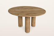Atzara round oak dining table in Natural, three-quarter view on a warm white studio backdrop: a thin 55 in round top on three