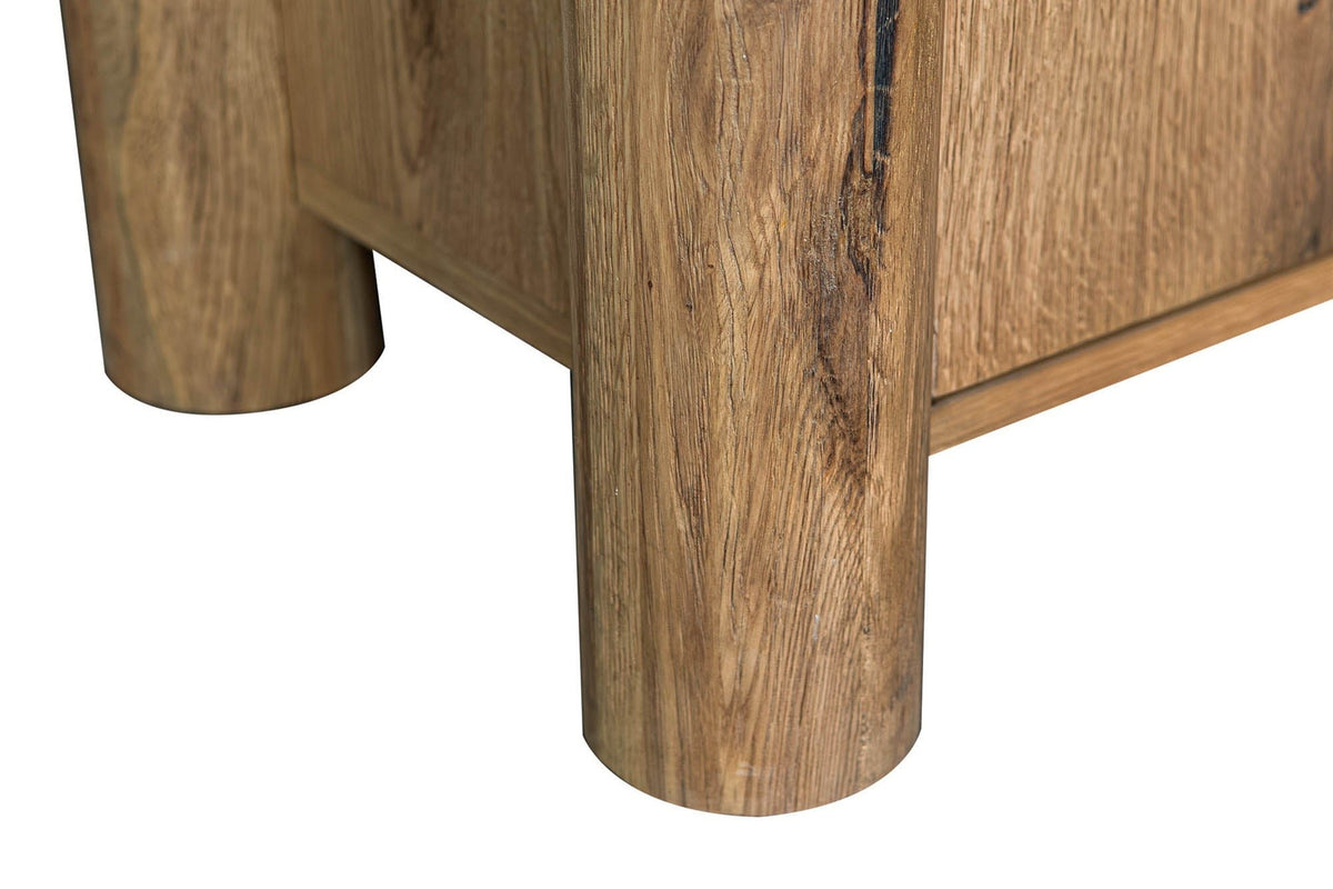 Close-up of two round column posts of the Atzara sideboard in Natural, standing on flat feet below the case